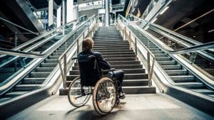 handibat - une personne en fauteuil roulant bloquée en bas d'escaliers et d'escalators